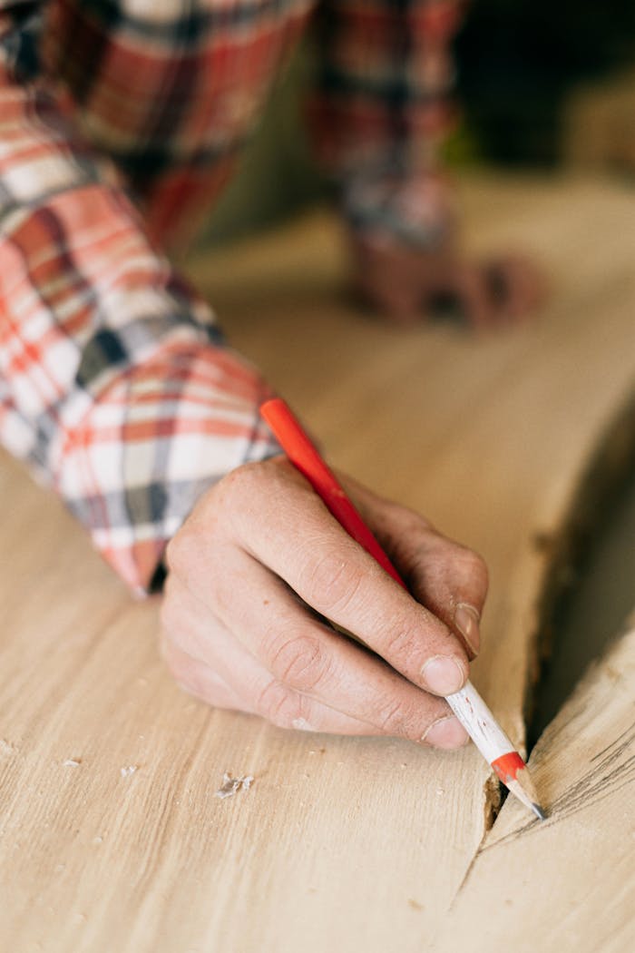 Crafting Captivating Headlines: Your awesome post title goes here Detailed image of a craftsman carefully marking wood for furniture making, emphasizing precision and skill.